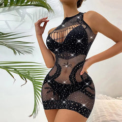 A woman wears the Plus Size Erotic Sexy Lingerie Bling Rhinestone Fishnet Bodysuit—a sleeveless, black mesh sex dress with sparkling rhinestones and cutouts; her face is unseen, set against a white wall and green palm leaves.