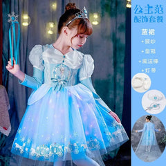 A young girl wears a blue Elsa-themed princess dress with a crown and matching accessories.