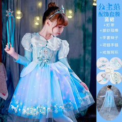A young girl wears a light blue Elsa princess dress with a tiara and matching accessories.