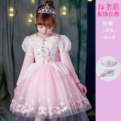 A young girl wears a pink princess dress featuring an Elsa graphic, puff sleeves, and a tulle skirt.