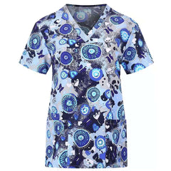 Blue V-neck scrub top with a patterned design of circular motifs and abstract shapes.