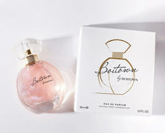A bottle of Boitown eau de parfum with pink shimmering liquid next to its white product box.