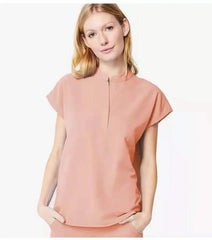 A woman wears a peach-colored short-sleeved medical scrub top with a mandarin collar.