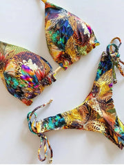 A colorful bikini set featuring a vibrant, multi-colored feather and animal print pattern.
