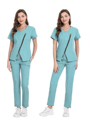 A woman wears a light blue medical scrub set featuring a V-neck top with a diagonal front zipper.