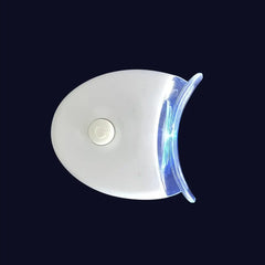 A white LED teeth whitening light with a curved mouthpiece on a dark background.
