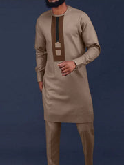 A man wears a tan long-sleeve tunic with a brown chest panel and matching trousers.