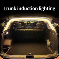 A motion sensor LED light strip installed along the interior edge of an open car trunk.
