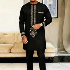 A man wears a black long-sleeve kaftan set with gold embroidery and matching trousers.