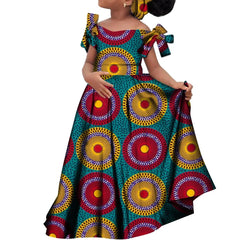 A girl wears a long, off-the-shoulder African print dress with a matching headscarf.