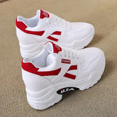 A pair of white platform sneakers with red accents and a lace-up closure.