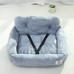 A light blue plush pet car seat with a black safety strap, suitable for small dogs or cats.