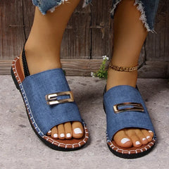 Denim flat sandals with a gold buckle detail and a black elastic back strap.