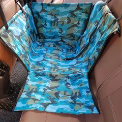 A blue camouflage pet car seat cover installed in the back seat of a vehicle.