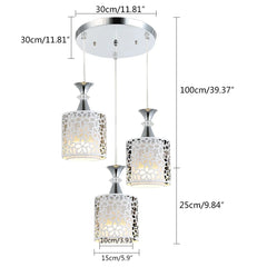 A modern three-light pendant chandelier featuring white floral-patterned iron shades.