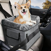 A grey portable dog booster seat with a plush interior sits on a car seat with a corgi inside.