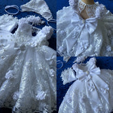 A white lace baptism gown for baby girls featuring 3D flowers, pearl accents, and a matching bonnet.