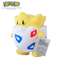 A yellow and white Togepi plush toy with red and blue triangle patterns on its egg-shaped body.
