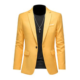 A yellow single-breasted blazer for men with a black shirt and a silver pendant necklace.
