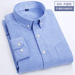A light blue long-sleeved Oxford button-down shirt with a chest pocket and striped collar lining.