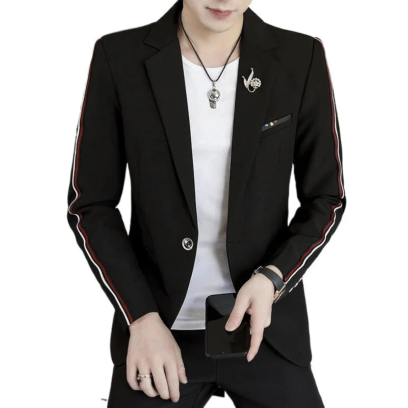 A man wears a black slim-fit suit jacket with red and white side stripes over a white t-shirt.