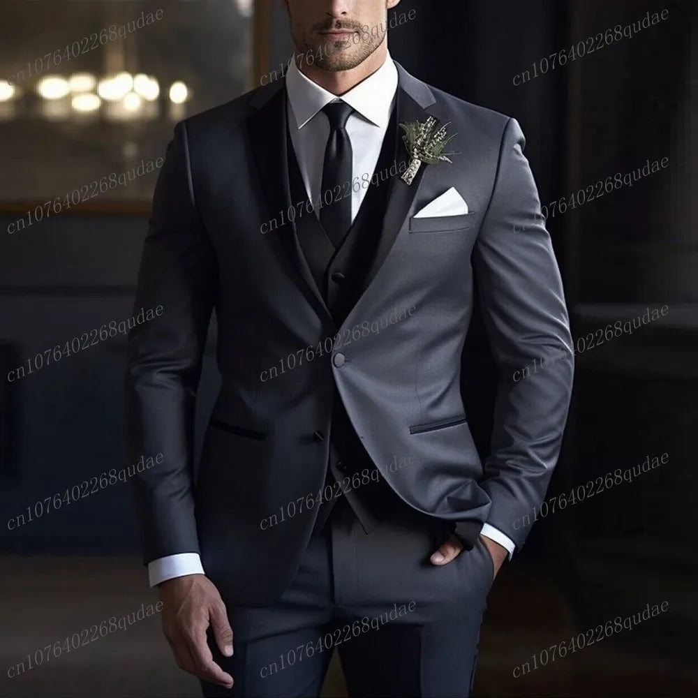 A man wears a charcoal grey three-piece suit with a black collar, white shirt, and black tie.