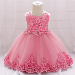 A sleeveless pink baby dress with floral lace embroidery and a full tulle ball gown skirt.