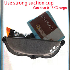 A grey felt cat hammock with a paw print cutout is mounted to a window with suction cups.