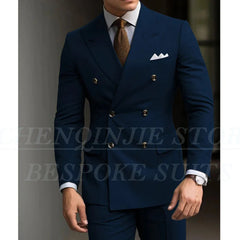A man wears a navy blue double-breasted slim-fit suit with a light shirt and brown tie.