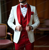 A man wears a white blazer with a red shawl lapel, red vest, and red bowtie for a formal event.