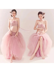 A pregnant woman wears a pink strapless tube top and a long, layered mesh tutu skirt.