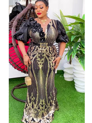 A woman wears a black and gold sequined maxi dress with puff sleeves and a decorative belt.