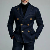 A man wears a dark denim double-breasted suit jacket with gold buttons over a black turtleneck.