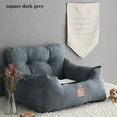 A square dark grey pet car seat with a cushioned backrest and a small logo patch on the front.