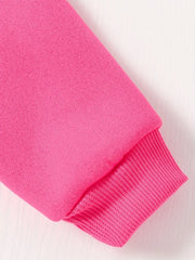 A close-up of a bright pink fleece sweatshirt sleeve with a ribbed cuff.
