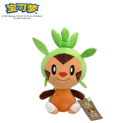 A plush toy of the Pokemon Chespin with a green hood and orange body sitting upright.