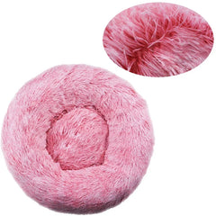 A round, pink plush pet bed with a soft, shaggy texture shown from a top-down perspective.