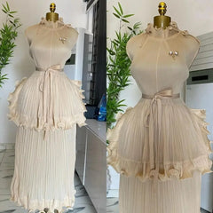 A beige sleeveless pleated midi dress with a ruffled peplum waist and a matching tie belt.