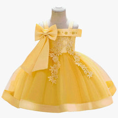 A sleeveless yellow knee-length ball gown for girls featuring a large bow and floral embroidery.