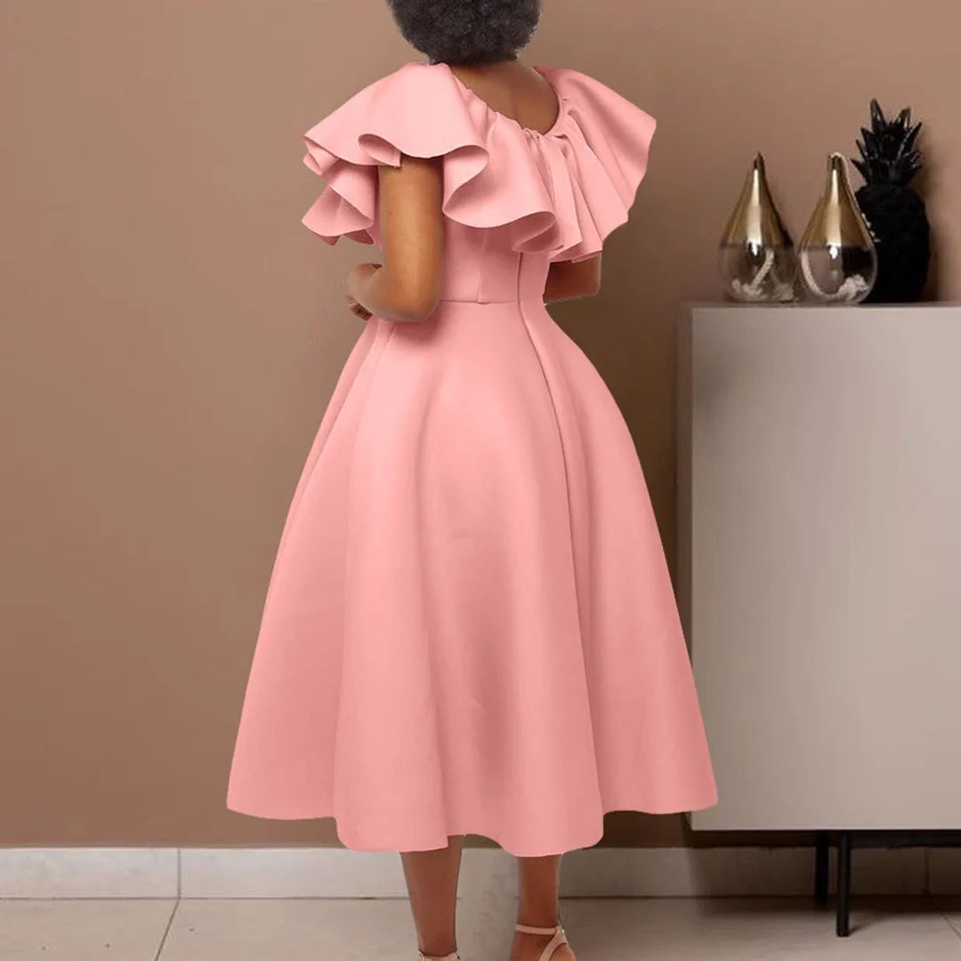 A woman wears a pink mid-calf A-line dress with ruffled butterfly sleeves and a round neckline.