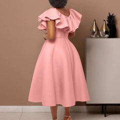 A woman wears a pink mid-calf A-line dress with ruffled butterfly sleeves and a round neckline.