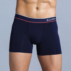 A man wearing navy blue cotton boxer shorts with a white and red striped waistband.