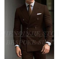 A man wears a slim-fit brown double-breasted suit with a light shirt and patterned tie.