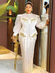 A woman wears a white floor-length gown with gold sequin stripes, puff sleeves, and floral accents.