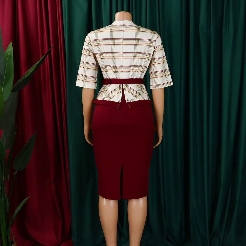 A woman wears a half-sleeve, plaid-patterned top with a maroon pencil skirt and a matching belt.