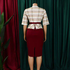 A woman wears a half-sleeve, plaid-patterned top with a maroon pencil skirt and a matching belt.