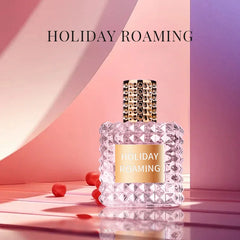 A square glass perfume bottle with a textured rivet pattern and a gold cap sits on a pink surface.