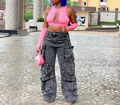 A woman wears high-waisted, loose-fitting grey acid-wash cargo jeans with multiple pockets.