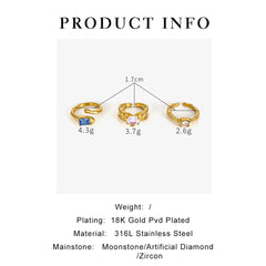 Three gold-plated stainless steel open rings with moonstone, blue, and clear stone accents.