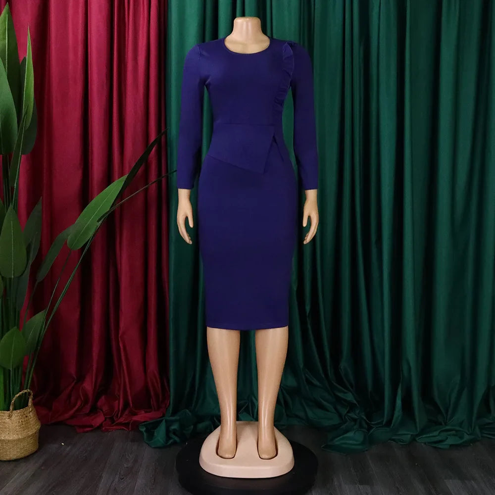 A long-sleeved, royal blue sheath dress with a round neckline and a ruffled waist detail.